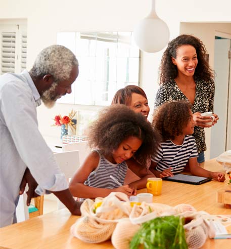 african-american-generational-family-cutting-vegetables-at-island